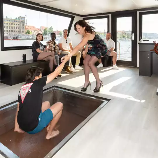 Group of people enjoying beer on a party boat on Vltava river.